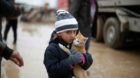 Malac, a 7-year-old, holds her cat as she walks back with her family to their home from Khazer camp, Iraq, January 22, 2017. 