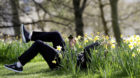 A visitor to St. James's Park takes a selfie while lying amongst daffodils, in London, Britain March 31, 2017.  REUTERS/Peter