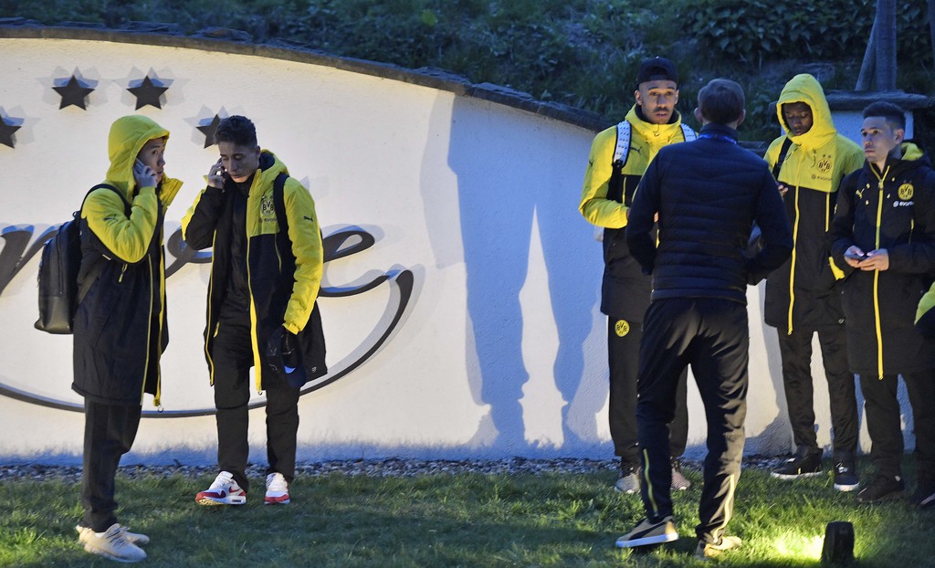 Dortmund players stand outside the team bus after it was damaged in an explosion before the Champions League quarterfinal soccer match between Borussia Dortmund and AS Monaco in Dortmund, western Germany, Tuesday, April 11, 2017. (AP Photo/Martin Meissner)