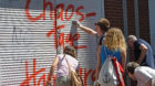 Residents clean a closed store, with spray-painted graffiti front that reads "Hamburg chaos days", during a "Clean-up" after 