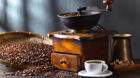 Cup of black coffee , coffee grinder and roasted beans on wooden table