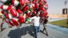 A man carries balloons decorated with Kurdistan flags before the start of a rally calling to vote yes in the coming referendu
