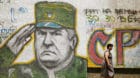 FILE PHOTO: A woman walks past a mural of Bosnian Serb wartime general Ratko Mladic in Belgrade, Serbia June 11, 2009. REUTER