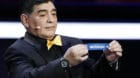 Argentine soccer legend Diego Maradona holds up the team name of Switzerland during the 2018 soccer World Cup draw in the Kre