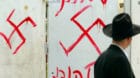 PETAH TIKVA, ISRAEL - MARCH 5:  (ISRAEL OUT)  A Jewish man looks at anti-semitic graffiti which was sprayed on the gate of a 