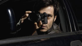 A man doing surveillance with a camera from his car PUBLICATIONxINxGERxSUIxAUTxONLY Copyright: MarcoxBaass fStopImages688047